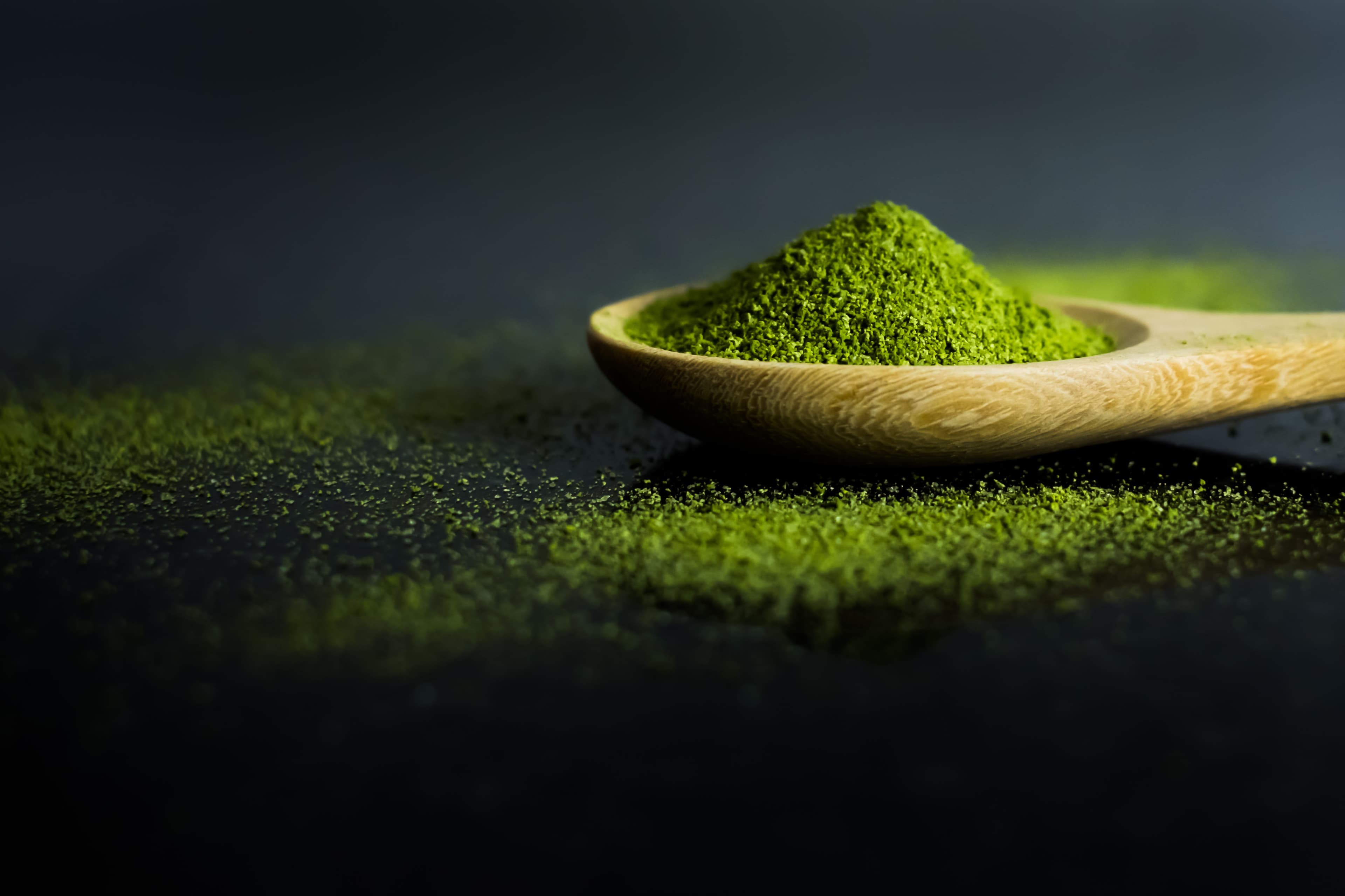 Fine matcha powder on a wooden spoon