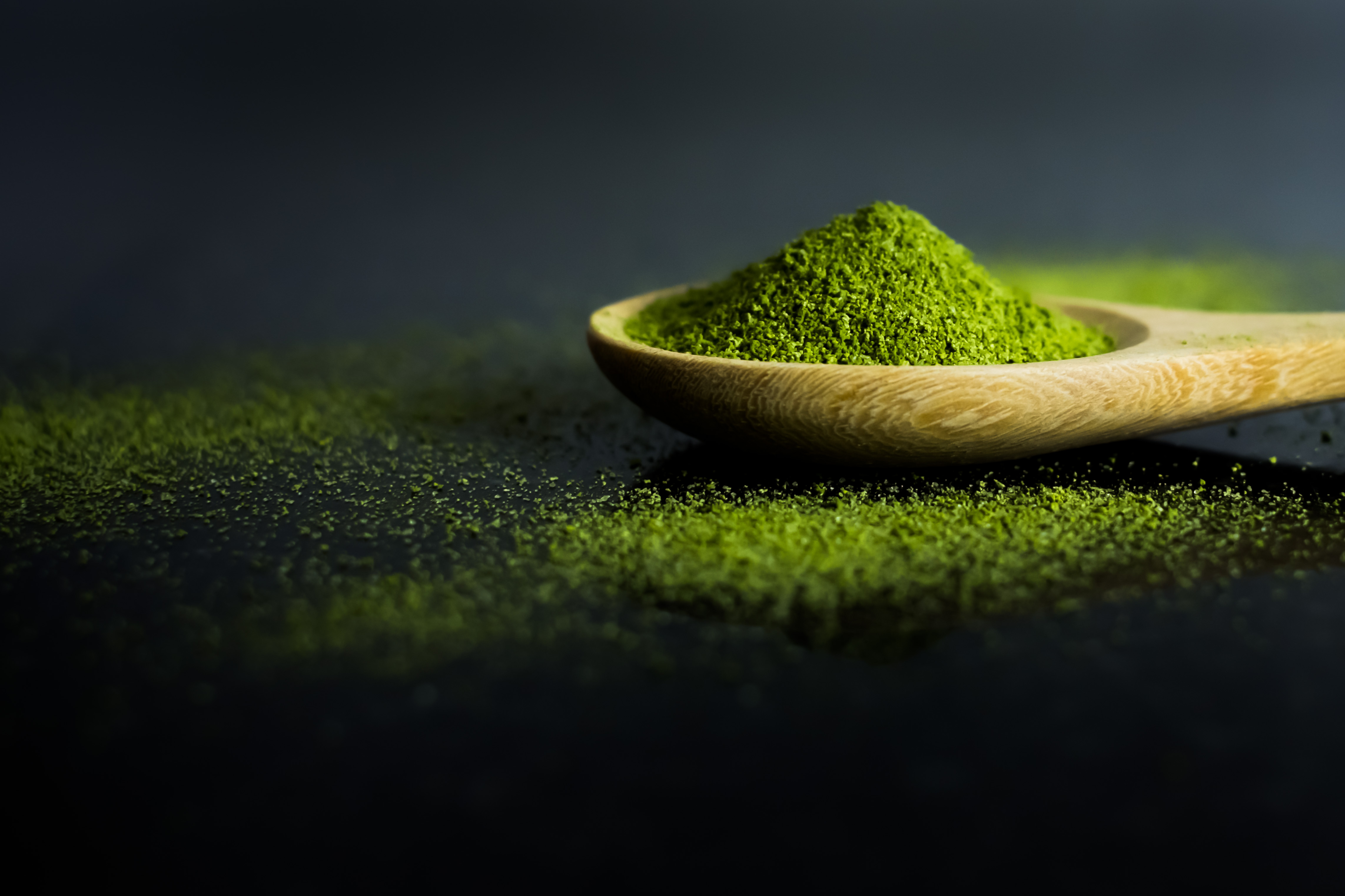 Fine matcha powder on a wooden spoon
